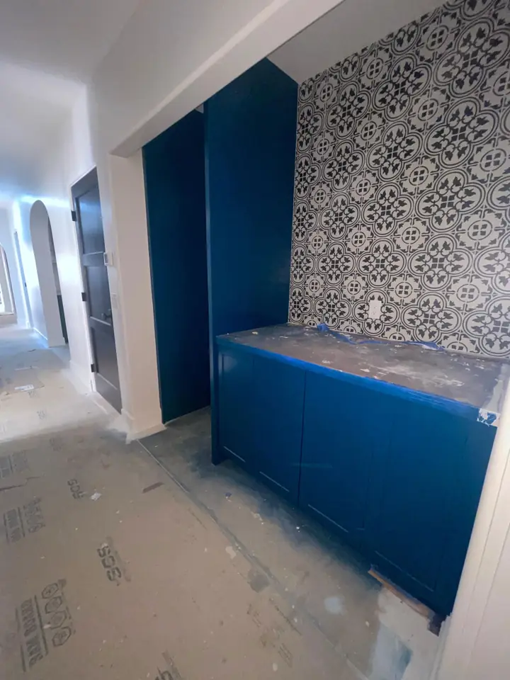 Deep blue accent wall paired with patterned wallpaper in a residential interior