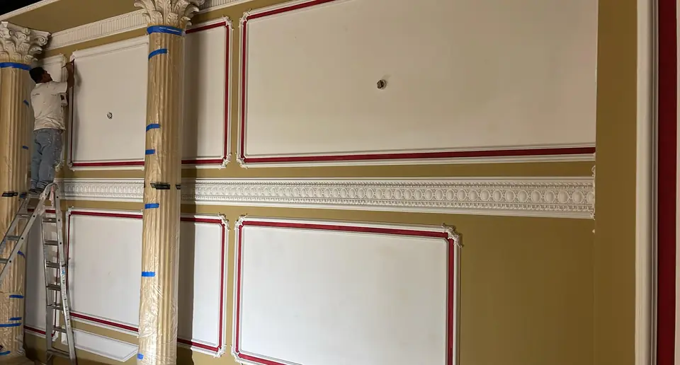 Painter applying a decorative trim detail to an interior wall