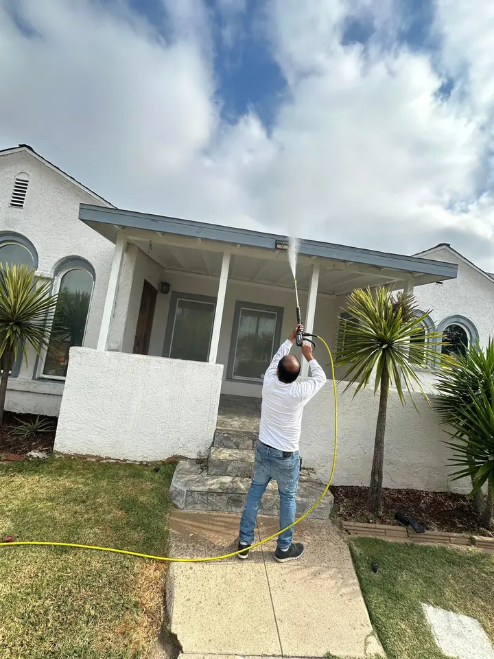 Painter working on the front porch columns of a home exterior